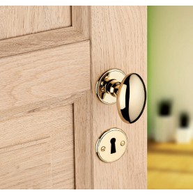 Bouton olive en laiton sur porte en bois