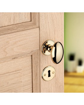 Bouton olive en laiton sur porte en bois